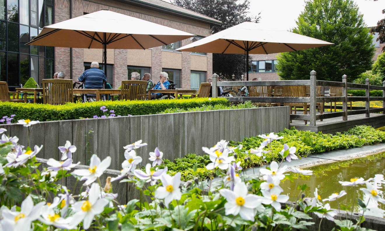 Seniorenzorg Philippus Neri bewoners op terras met bloeiende bloemen in Avondzegen