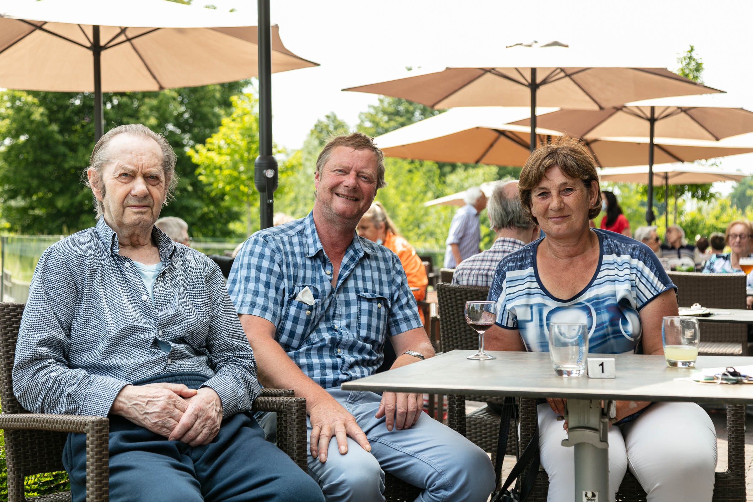 Seniorenzorg Philippus Neri familie op bezoek bij senior heer op terras buiten