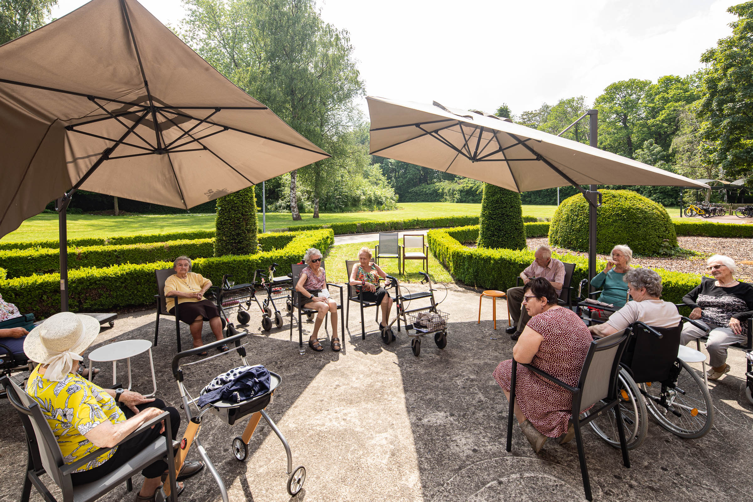 Seniorenzorg Philippus Neri senior bewoners op het ruime terras achteraan met zicht op de tuin van Huize Den Dries in Sinaai