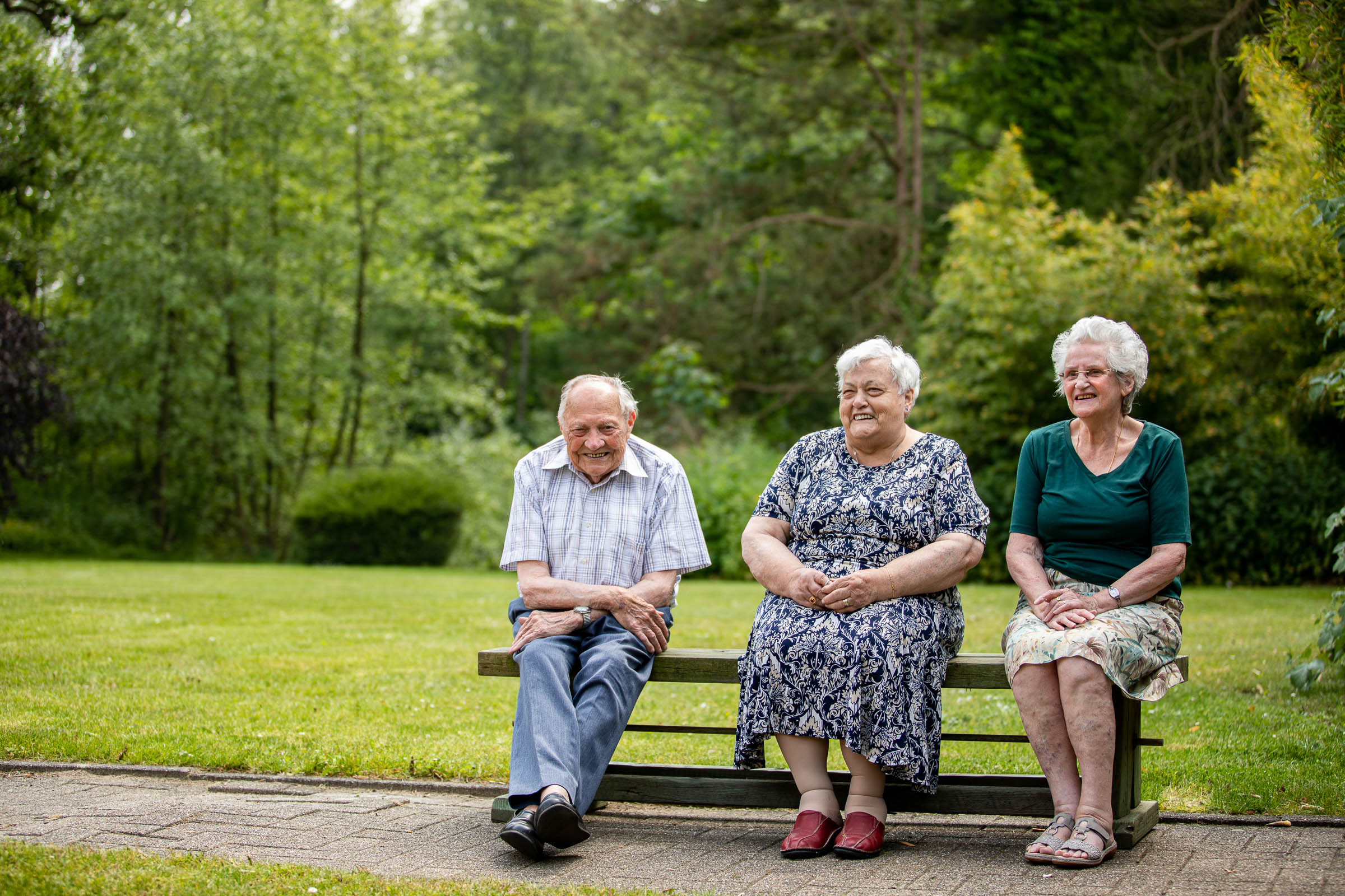 Seniorenzorg Philippus Neri drie senior bewoners genieten van een momentje rust in het park van Huize Den Dries in Sinaai