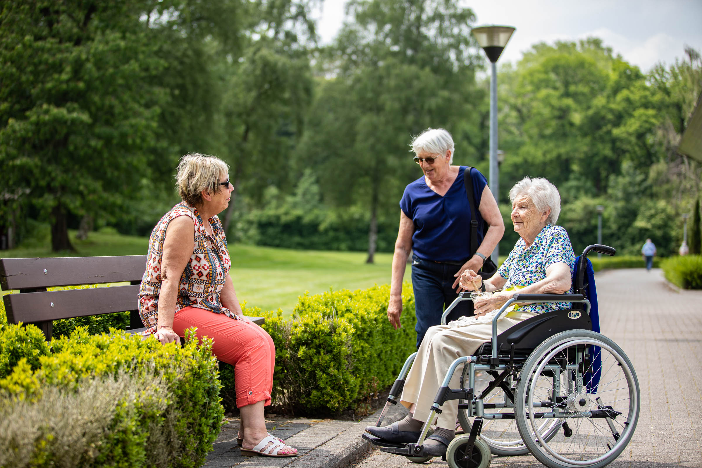 Seniorenzorg Philippus Neri familieleden op wandel met senior bewoner in rolstoel bij Huize Den Dries in Sinaai