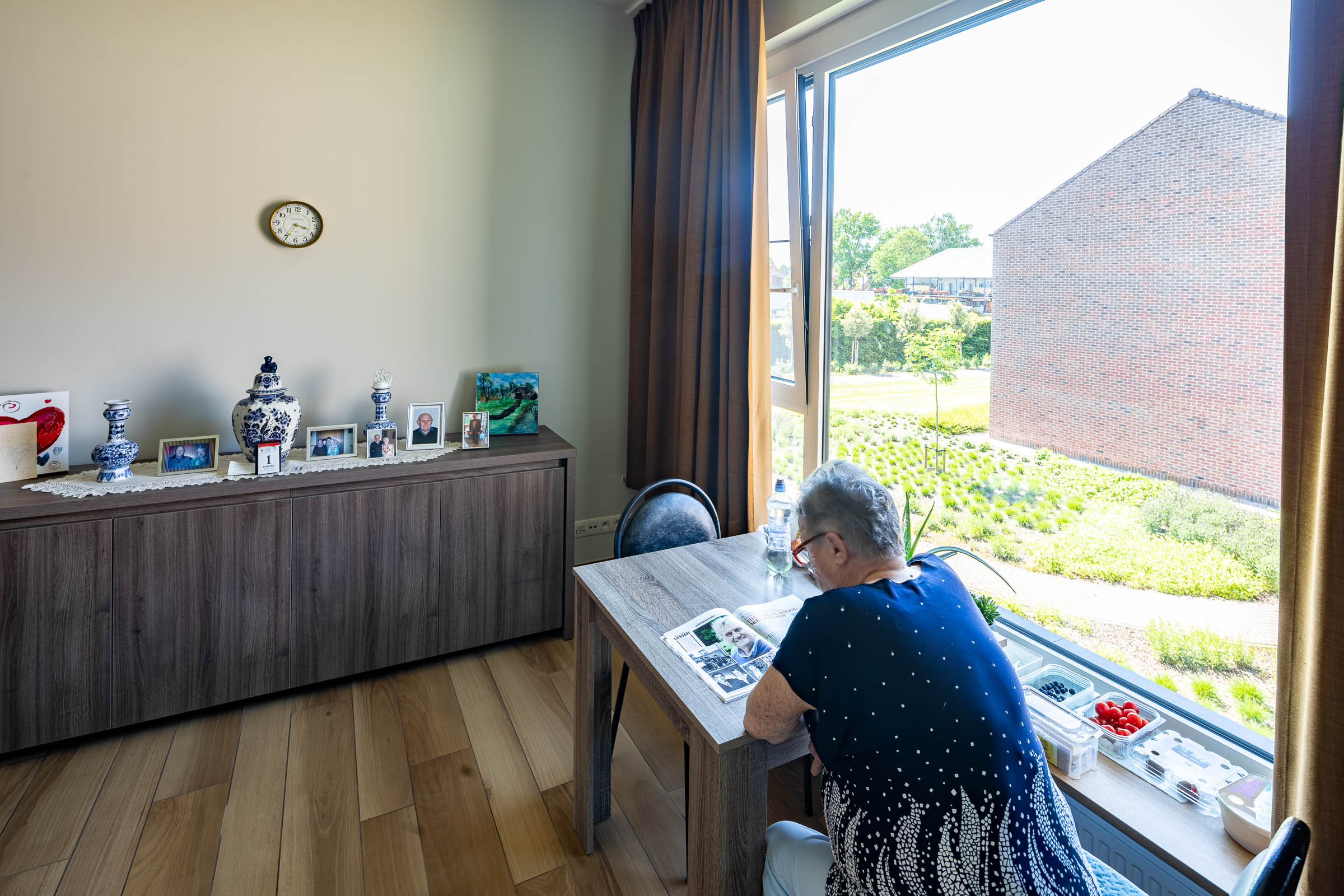 Seniorenzorg Philippus Neri senior dame aan het lezen op haar kamer aan het raam in woonzrgcentrum Sint-Jozef