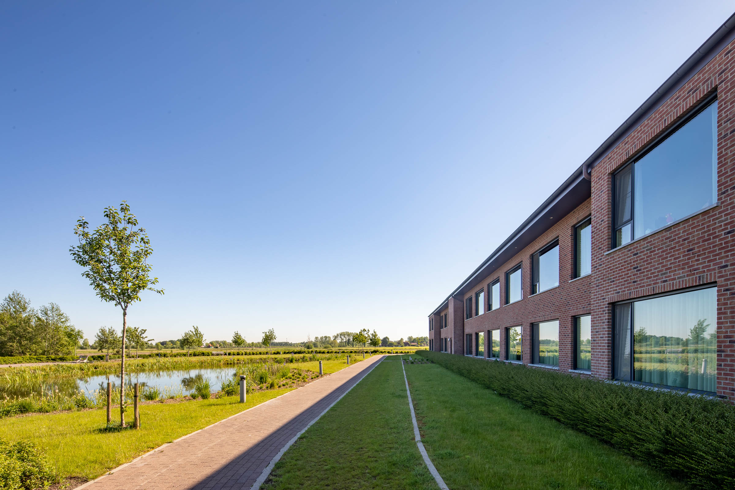 Seniorenzorg Philippus Neri wandelpad langs de achterzijde van het gebouw Sint-Jozef in groene omegving